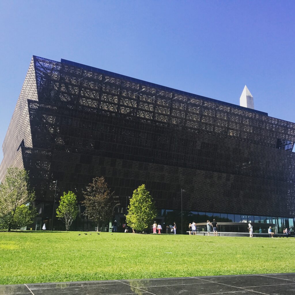 Smithsonian National Museum of African American History & Culture exterior with the Washington Monument peeking over the top